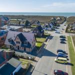 Aussicht auf Stranddorf mit Häusern und Parkplatz
