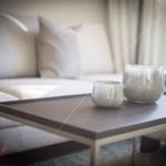 Tisch mit zwei Keramikgefäßen vor einem Sofa