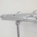 Shower area with chrome shower system and flexible hose connection.