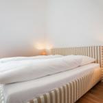 Bedroom with bed, nightstand, and lamp.