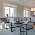 Living and dining area with sofa, table, and windows.