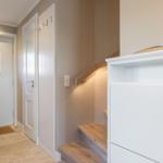 Entrance area with stairs, white doors, and wooden steps.