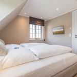Bedroom with double bed, window, and wall picture.