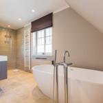 Bathroom with freestanding bathtub, shower, and window