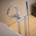 Shower head and faucet beside white bathtub rim