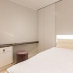 Bedroom with bed, nightstand, and wardrobe.