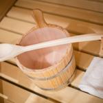 Wooden bucket with ladle and towel on bench