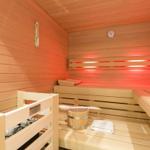 Sauna with wooden bench, bucket, and thermometer