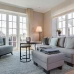 Living room with sofa, armchair, and large windows.
