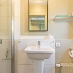 Bathroom with shower, sink, and mirror