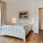 Bedroom with double bed, wardrobe, and large window with view.