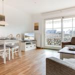 Living and dining area with view of the beach and stone barrier.