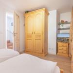 Room with two beds, wardrobe, and TV.