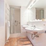 Bathroom with shower, two sinks, and window