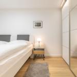 Bedroom with double bed, nightstand, and mirrored wardrobe.