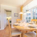 Dining room with wooden table, chairs, and view of garden