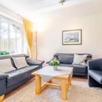 Living room with two sofas, armchair, table, and wall picture.