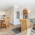 Living and dining area with wooden table, chairs, and sofa.