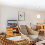 Living and dining area with TV, chair, and table.