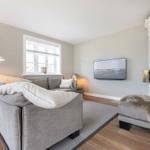 Wohnzimmer mit Sofa, Fernseher und Kamin