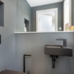 Badezimmer mit Waschbecken, Spiegel und Keramikfigur