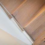 Holzgetreppe mit sichtbaren Nähten und natürlichen Maserungen an der Wand