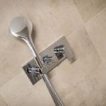Moderne Dusche mit Handbrause und zwei Hebeln an Wand