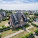 Haus mit Steinmauer und Parkplatz, Blick auf Meer und Umgebung.
