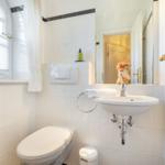 Bathroom with toilet, sink, and window.