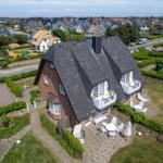 House with terrace and garden. View of residential area and street.