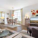 Living and dining area with wooden furniture, TV, and window.