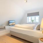 Bedroom with bed, window, and TV.