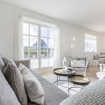 Living area with sofa, seating, and window view.