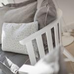 White chair with gray cushions and patterned cushions