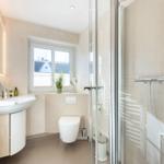 Bathroom with shower, sink, and toilet. Window with plant.