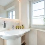 Sink with mirror, window, and plant