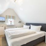 Bedroom with double bed, TV, and window.