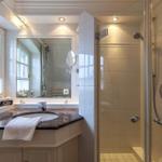 Bathroom with shower, sink, and window.