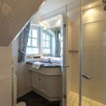 Bathroom with shower, sink, and window.