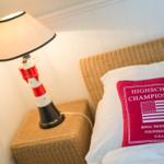 Bedroom with lighthouse lamp, pillow, and wicker headboard.