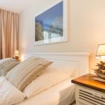 Bedroom with bed, nightstand, and wall picture