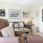 Living room with armchair, sofa, table, and wall decor.