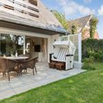 Terrace with dining table, lounge chair, and lawn