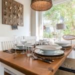 Dining table with chairs and garden view through window