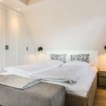 Schlafzimmer mit Doppelbett, Kleiderschrank und Nachttisch.