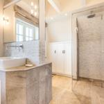 Bad mit Dusche, Waschbecken und Spiegel