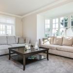 Wohnzimmer mit zwei Sofas, Couchtisch und Fenstern.
