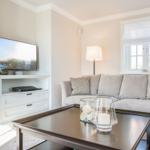 Ein Wohnzimmer mit Sofa, Fernseher und Tisch.