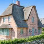 Haus mit Strohdach, Backsteinfassade und grüner Tür