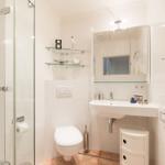 Badezimmer mit Dusche, Waschbecken und Toilette.